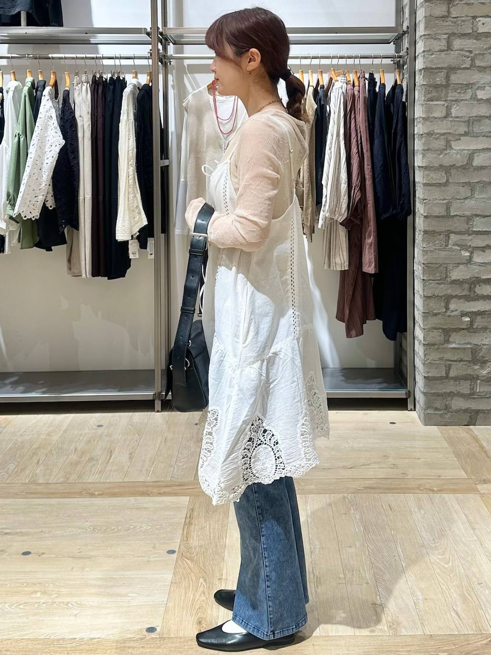 ブラック系のショルダーバッグ、ホワイト系のキャミソール、ブラック系のパンプスを着用したレディースの春コーディネートの2枚目の写真