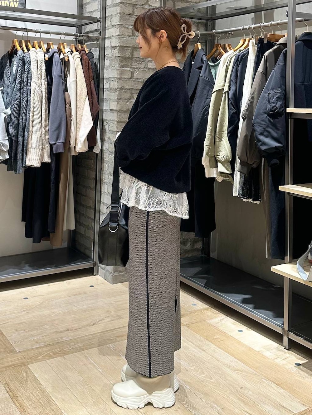 ホワイト系のブーツ、ブラック系のスカート、ブラック系のその他アウターを着用したレディースの冬コーディネートの6枚目の写真