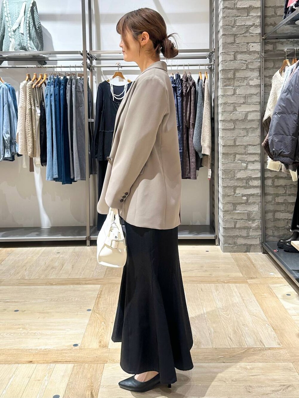 ブラウン系のテーラードジャケット、ホワイト系のTシャツ/カットソー、ブラック系のパンプスを着用したレディースの冬コーディネートの2枚目の写真