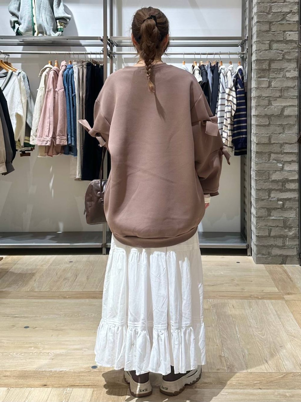 ブラウン系のスウェット、ホワイト系のTシャツ/カットソー、ブラック系のボストンバッグを着用したレディースの冬コーディネートの3枚目の写真