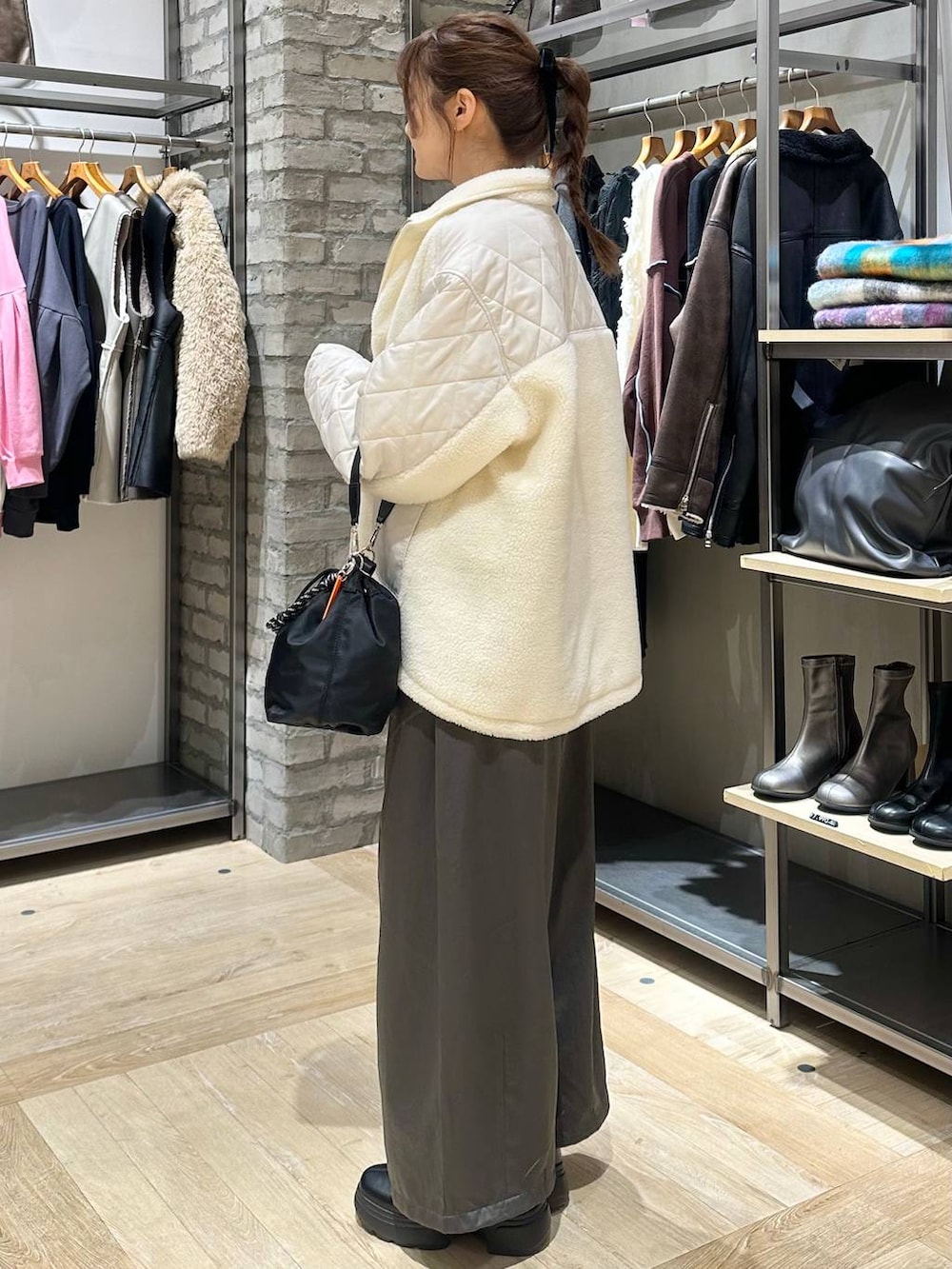 ブラック系のショルダーバッグ、ホワイト系のブルゾン、グレー系のその他パンツを着用したレディースの冬コーディネートの6枚目の写真