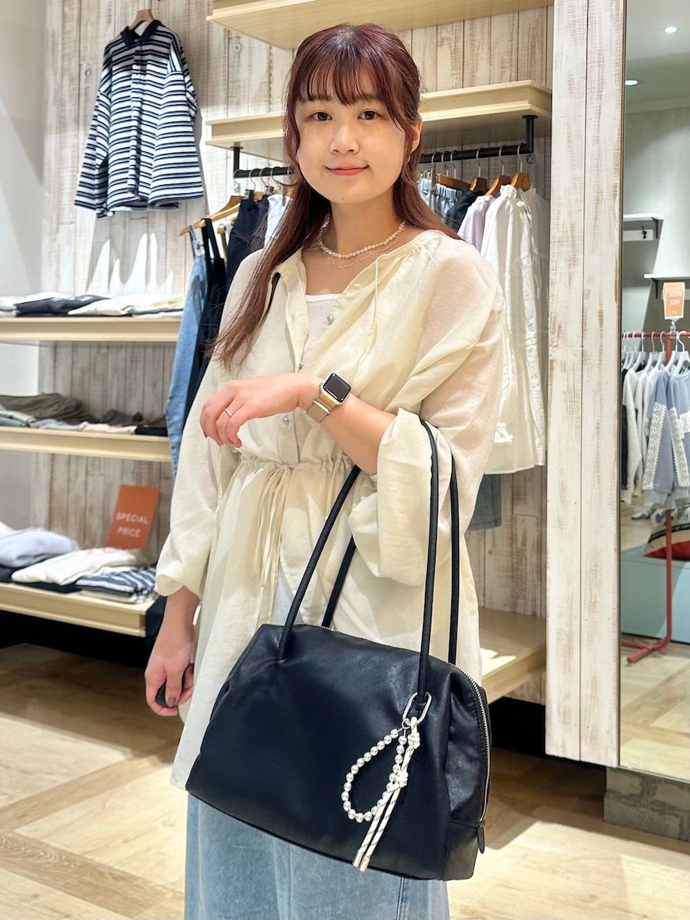 ブルー系のデニムパンツ、ブラック系のボストンバッグ、ホワイト系のシャツ/ブラウスを着用したレディースの春コーディネートの4枚目の写真