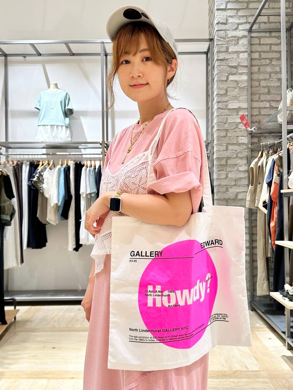 ブラック系のサンダル、ブルー系のデニムパンツ、ピンク系のトートバッグを着用したレディースの夏コーディネートの5枚目の写真