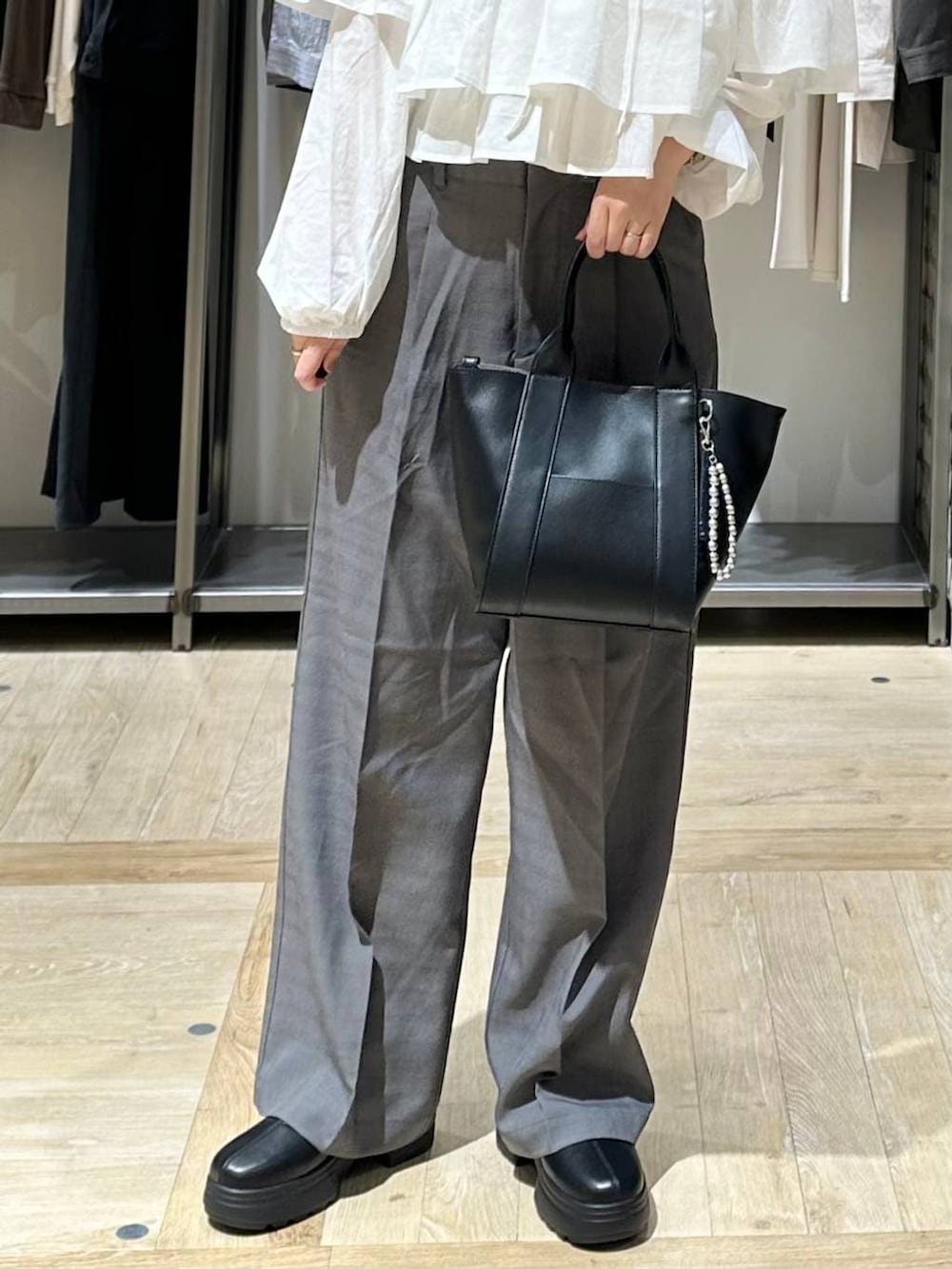その他のその他パンツ、ブラック系のトートバッグ、ブラック系のブーツを着用したレディースの秋コーディネートの5枚目の写真