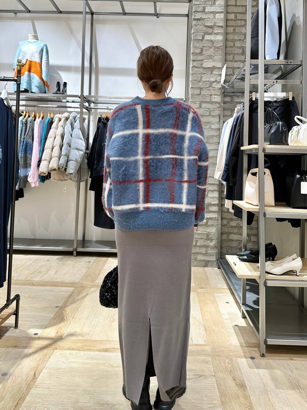 ブラック系のショルダーバッグ、グレー系のスカート、ブラック系のブーツを着用したレディースの冬コーディネートの3枚目の写真