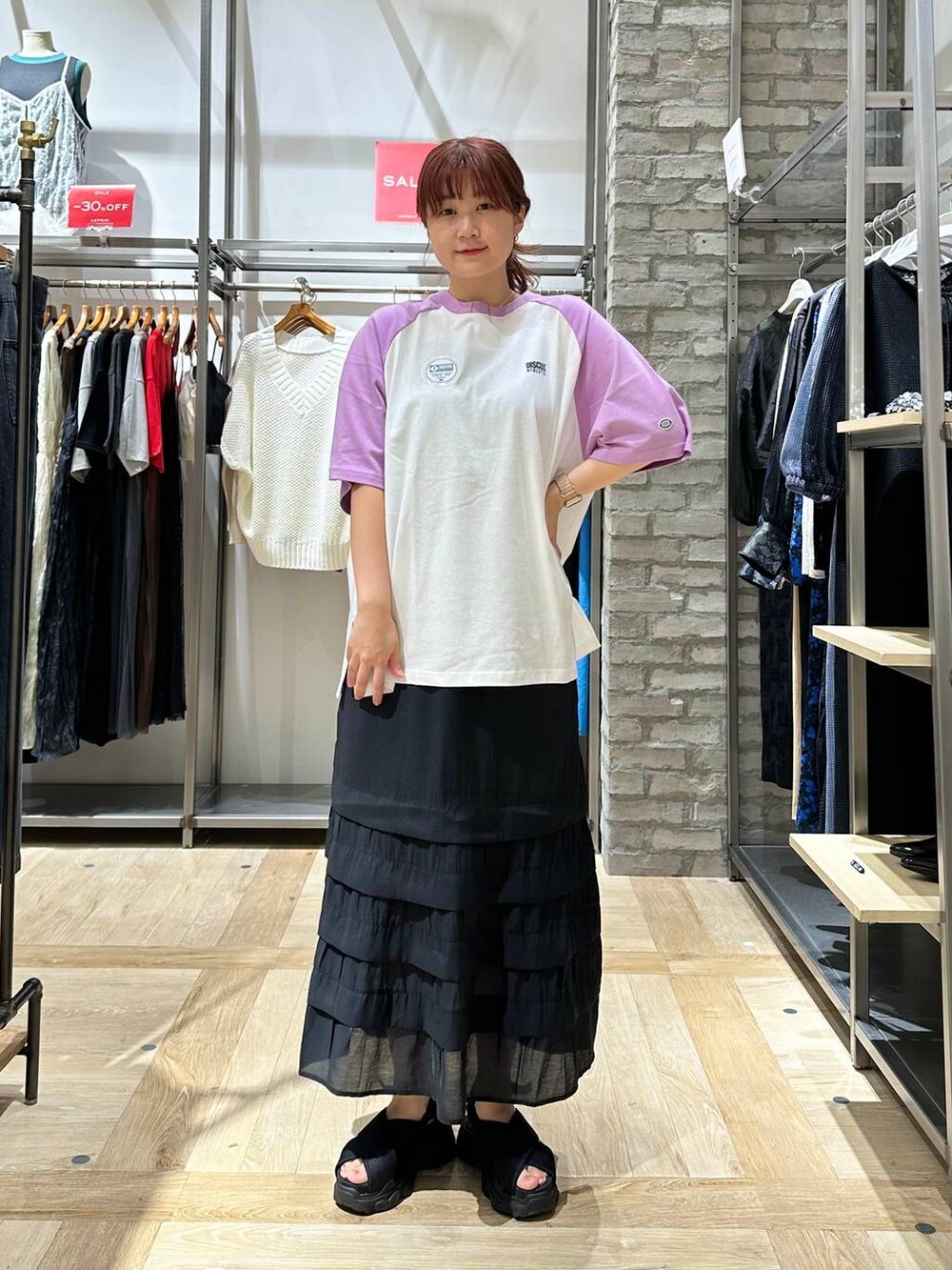 ブラック系のスカート、ブラック系のショルダーバッグ、ブラック系のサンダルを着用したレディースの夏コーディネートの2枚目の写真