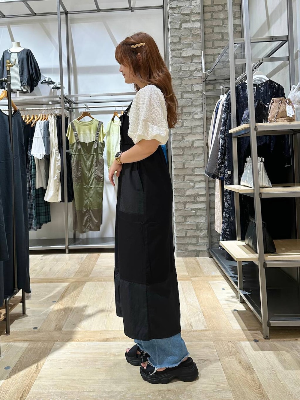 ホワイト系のTシャツ/カットソー、ブルー系のデニムパンツ、ブラック系のサンダルを着用したレディースの夏コーディネートの2枚目の写真