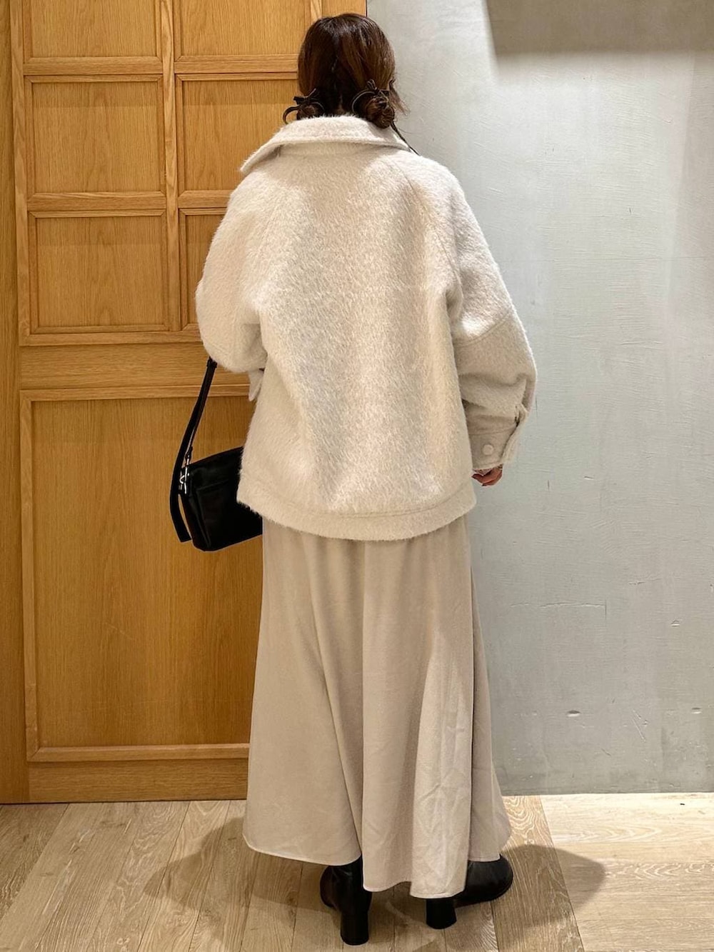 ホワイト系のTシャツ/カットソー、ブラック系のショルダーバッグ、ブラック系のブーツを着用したレディースの冬コーディネートの8枚目の写真