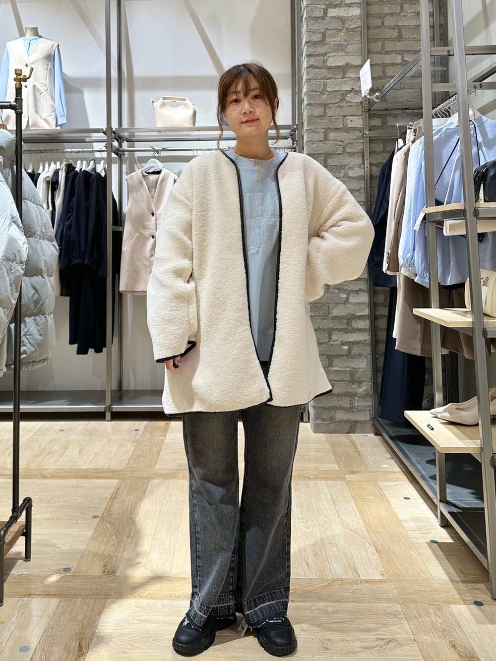 ブラック系のショルダーバッグ、ブラック系のスニーカー、ブルー系のスウェットを着用したレディースの冬コーディネートの4枚目の写真