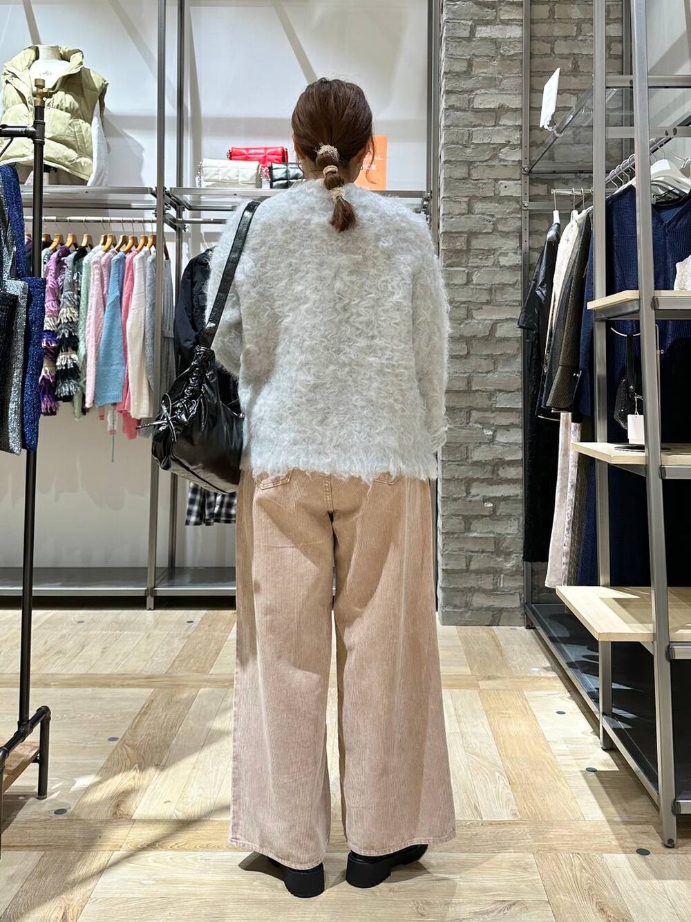 ブラック系のブーツ、ホワイト系のニット/セーター、グレー系のカーディガン/ボレロを着用したレディースの冬コーディネートの3枚目の写真