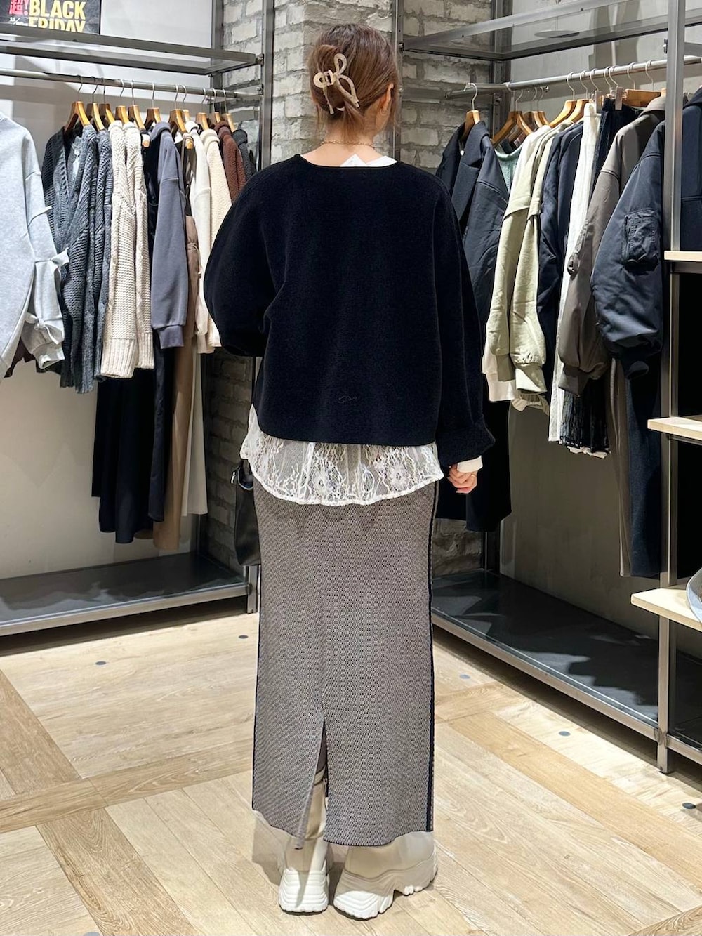 ホワイト系のブーツ、ブラック系のスカート、ブラック系のその他アウターを着用したレディースの冬コーディネートの7枚目の写真