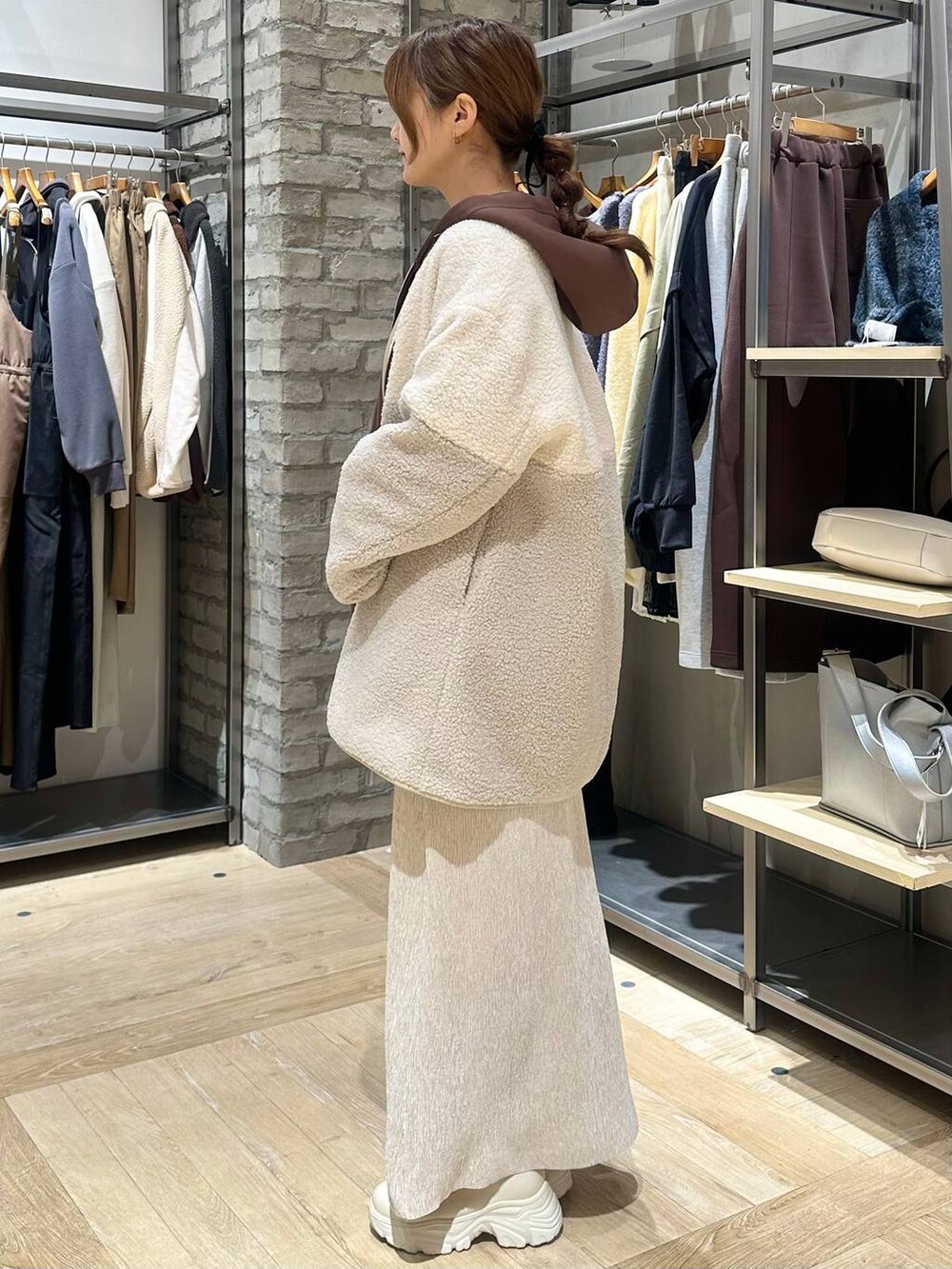 ホワイト系のブーツ、ブラウン系のニット/セーター、ホワイト系のその他アウターを着用したレディースの冬コーディネートの6枚目の写真