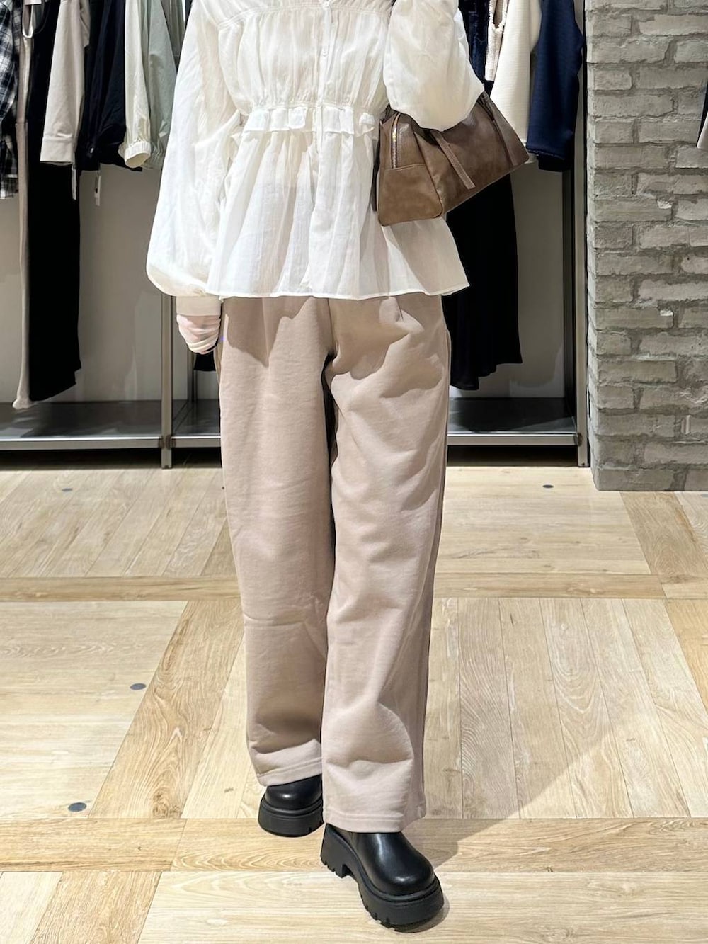 ブラウン系のボストンバッグ、ホワイト系のTシャツ/カットソー、ベージュ系のスウェットパンツを着用したレディースの春コーディネートの5枚目の写真