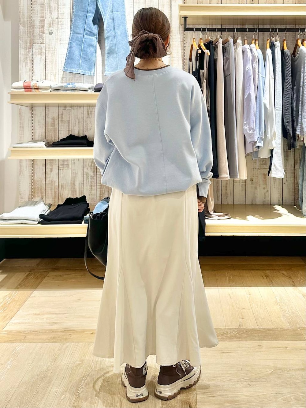 ホワイト系のスカート、ブラック系のトートバッグ、ブルー系のTシャツ/カットソーを着用したレディースの冬コーディネートの3枚目の写真