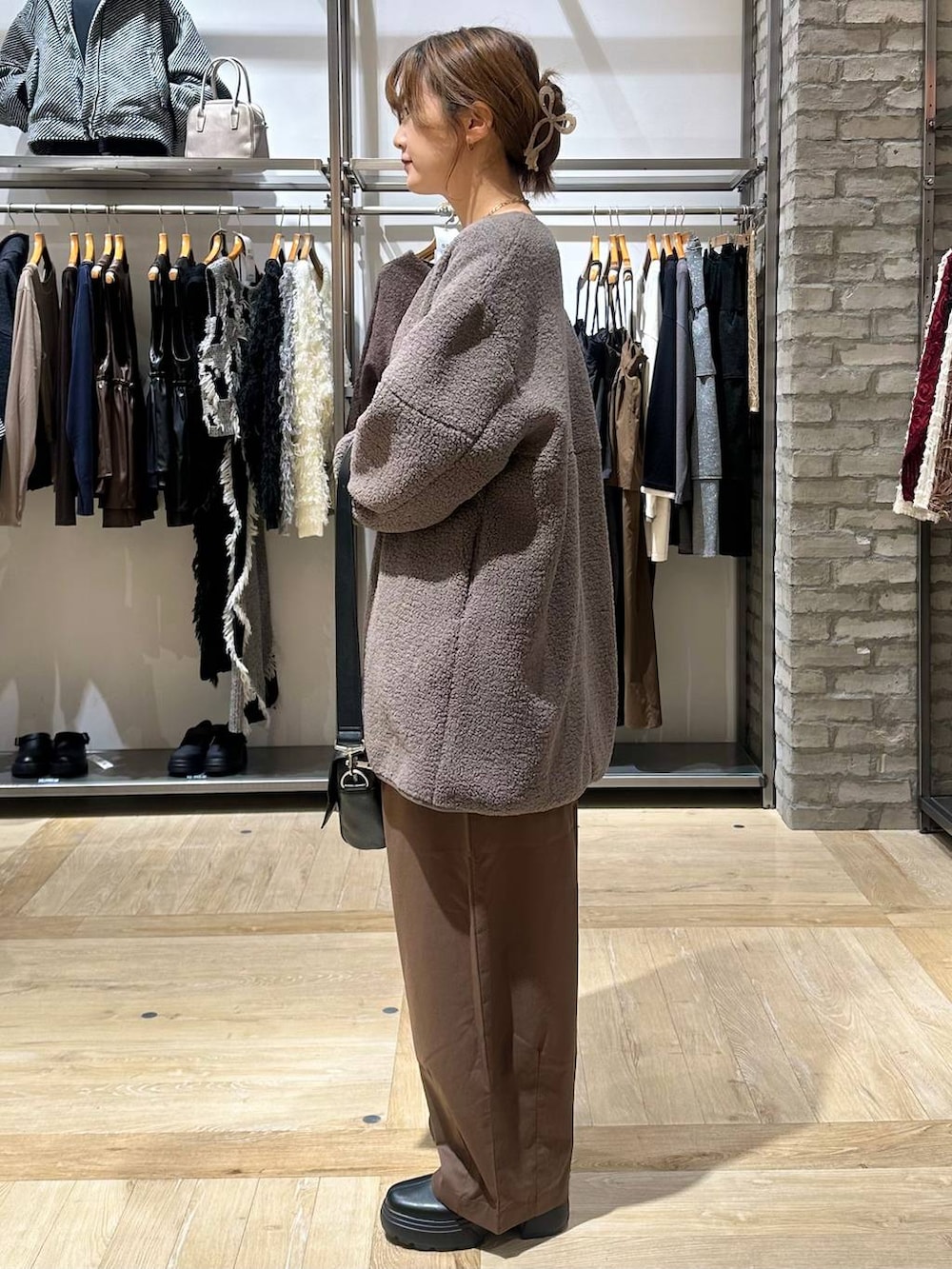 ホワイト系のニット/セーター、ブラック系のショルダーバッグ、ブラウン系のその他パンツを着用したレディースの秋コーディネートの2枚目の写真