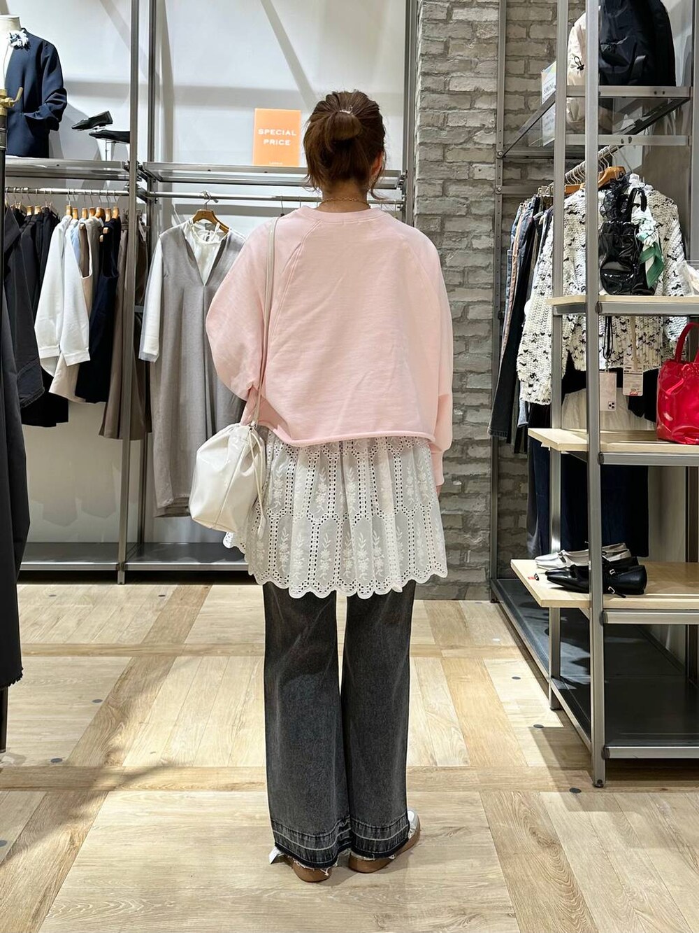 ホワイト系のTシャツ/カットソー、ブラック系のデニムパンツ、ホワイト系のスニーカーを着用したレディースの春コーディネートの4枚目の写真