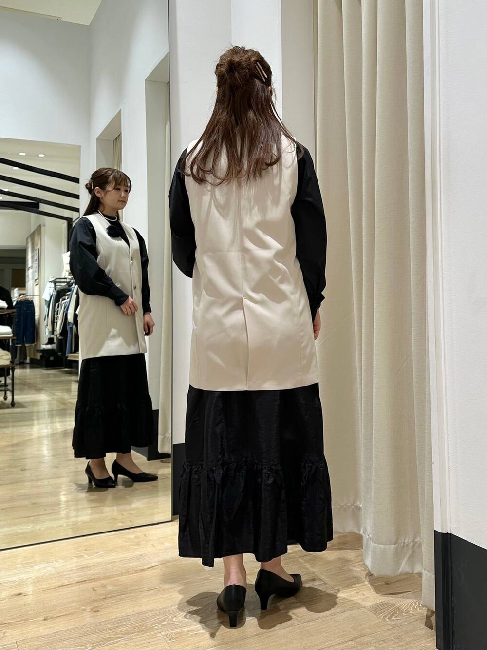 ブラック系のスカート、ブラック系のシャツ/ブラウス、ホワイト系のショルダーバッグを着用したレディースの冬コーディネートの4枚目の写真