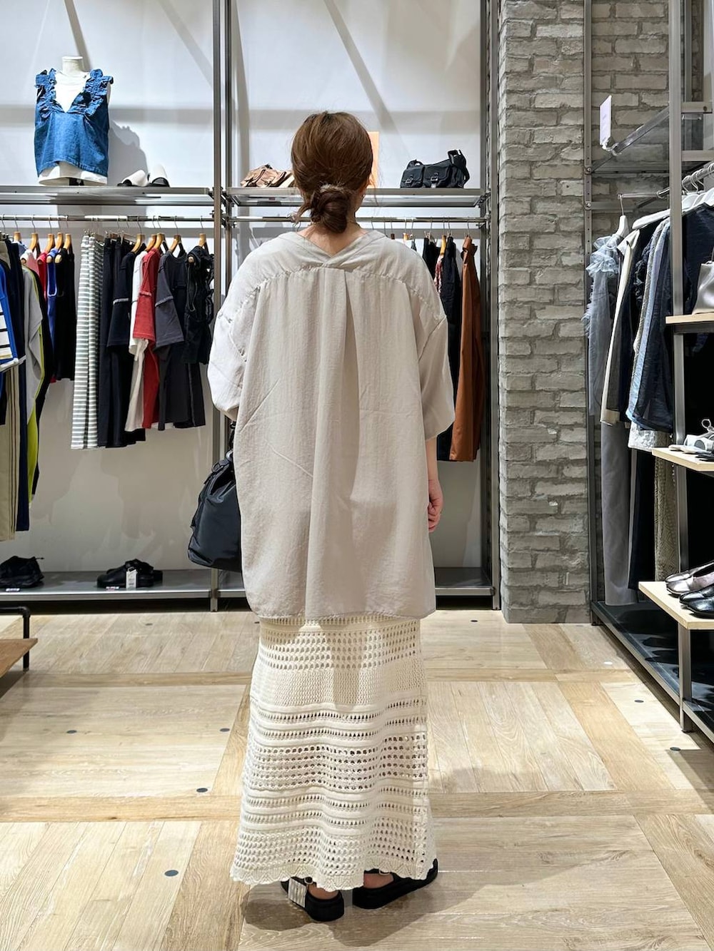 ブラック系のショルダーバッグ、ホワイト系のタンクトップ、ベージュ系のチュニックを着用したレディースの春コーディネートの3枚目の写真