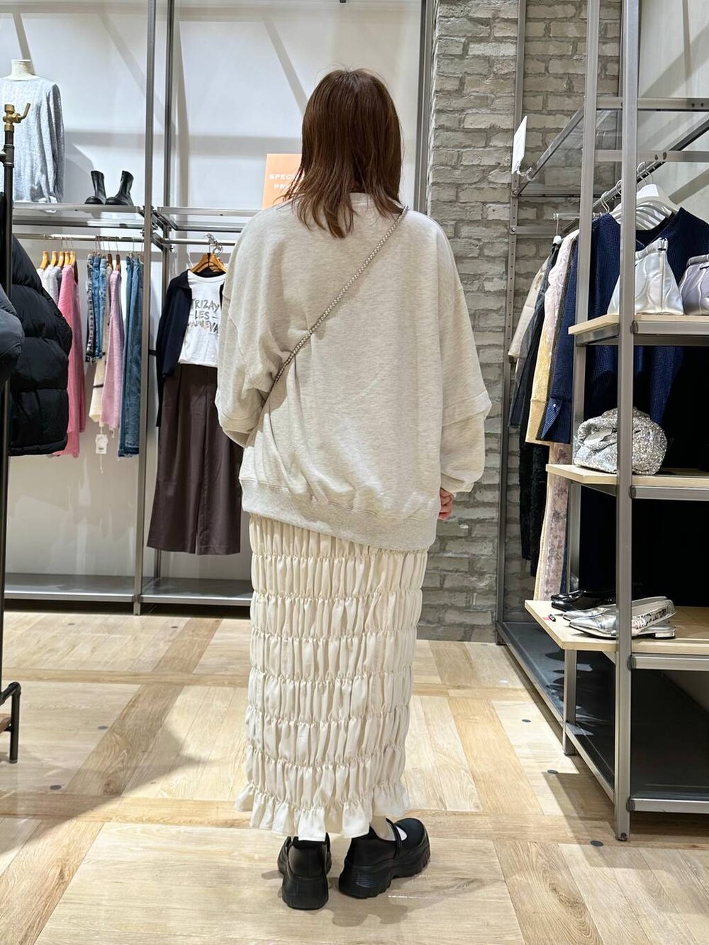 ブラック系のスニーカー、ホワイト系のスカート、ベージュ系のTシャツ/カットソーを着用したレディースの秋コーディネートの4枚目の写真