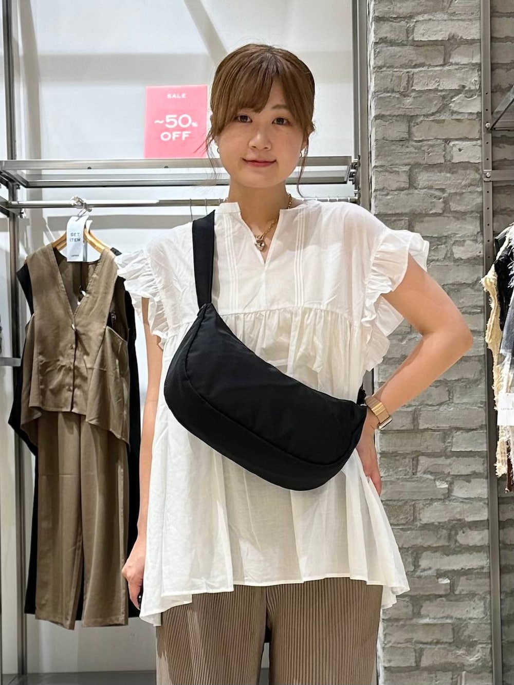 ブラウン系のその他パンツ、ブラック系のショルダーバッグ、ブラウン系のサンダルを着用したレディースの夏コーディネートの5枚目の写真