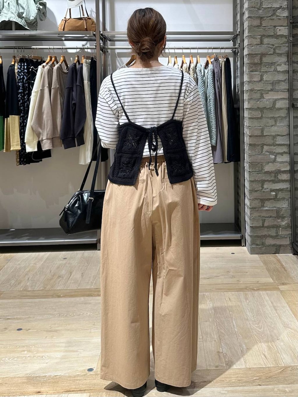 ブラック系のボストンバッグ、ホワイト系のTシャツ/カットソー、ベージュ系のその他パンツを着用したレディースの春コーディネートの3枚目の写真