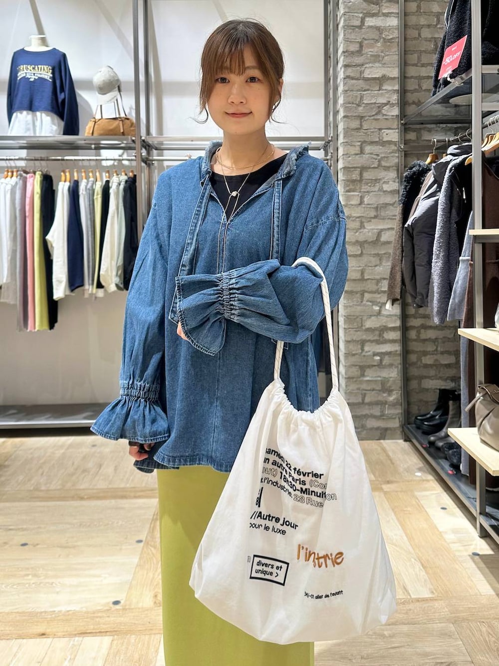 グリーン系のスカート、ブラック系のTシャツ/カットソー、ホワイト系のトートバッグを着用したレディースの冬コーディネートの5枚目の写真