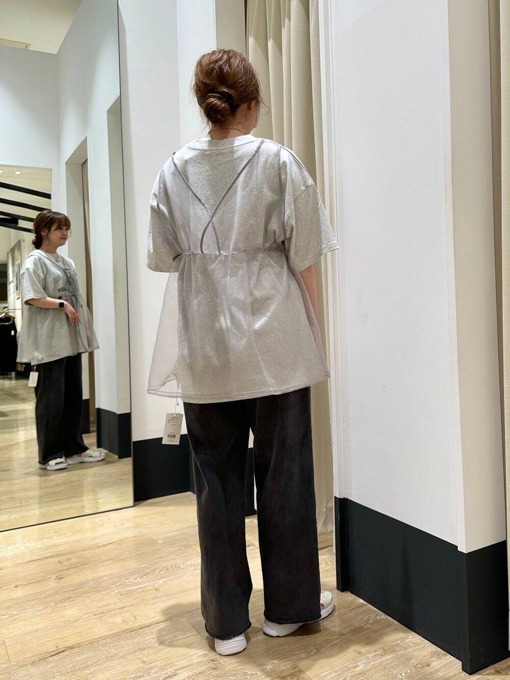 ホワイト系のサンダル、グレー系のベスト、ブラック系のデニムパンツを着用したレディースの春コーディネートの5枚目の写真