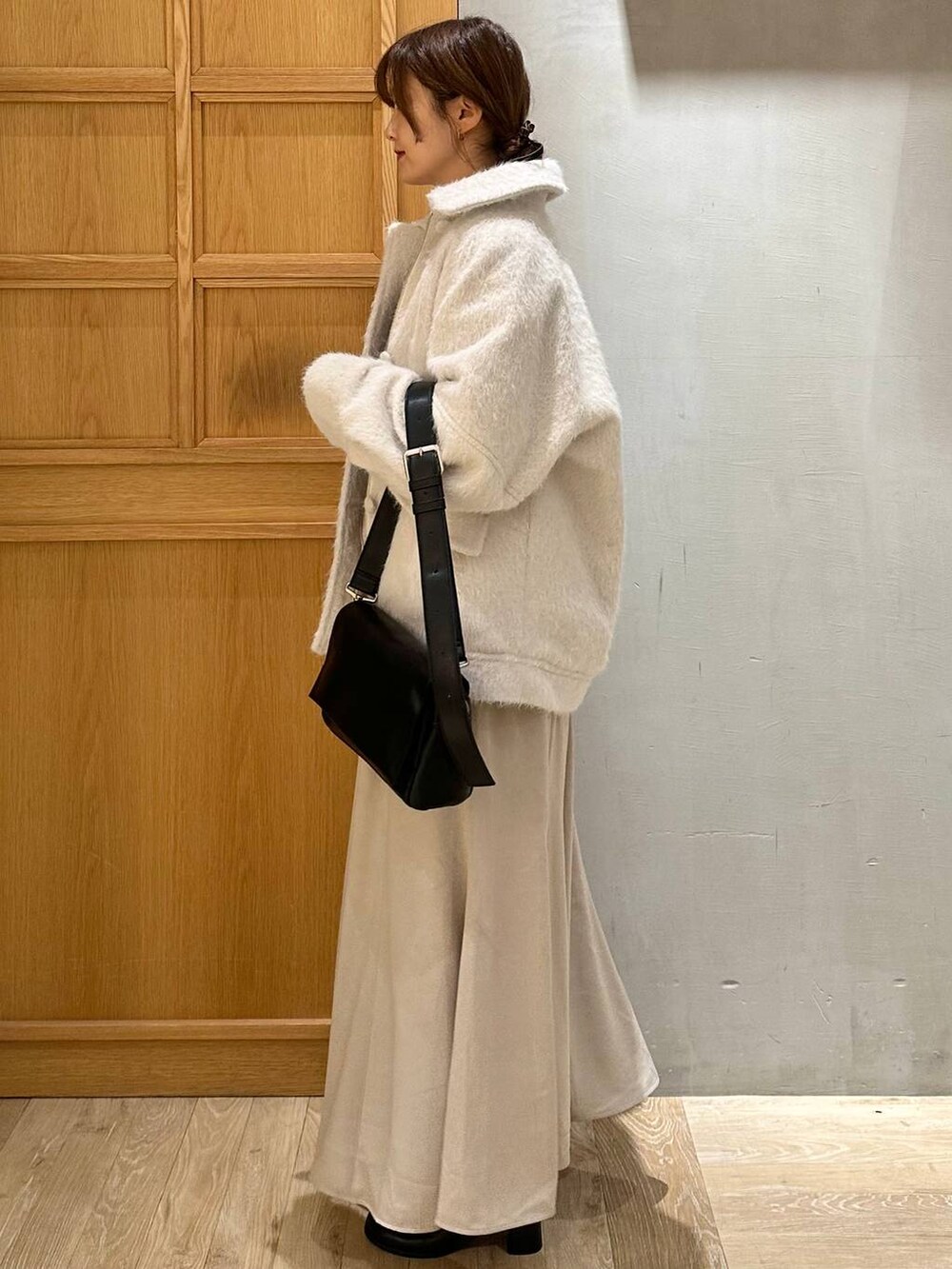 ホワイト系のTシャツ/カットソー、ブラック系のショルダーバッグ、ブラック系のブーツを着用したレディースの冬コーディネートの7枚目の写真