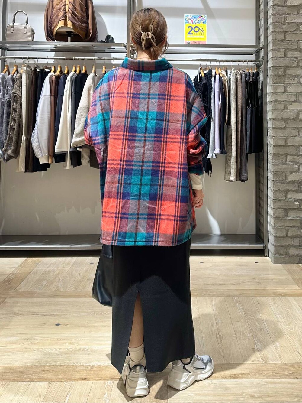 ブラック系のスカート、ホワイト系のスニーカー、ブラック系のショルダーバッグを着用したレディースの秋コーディネートの3枚目の写真