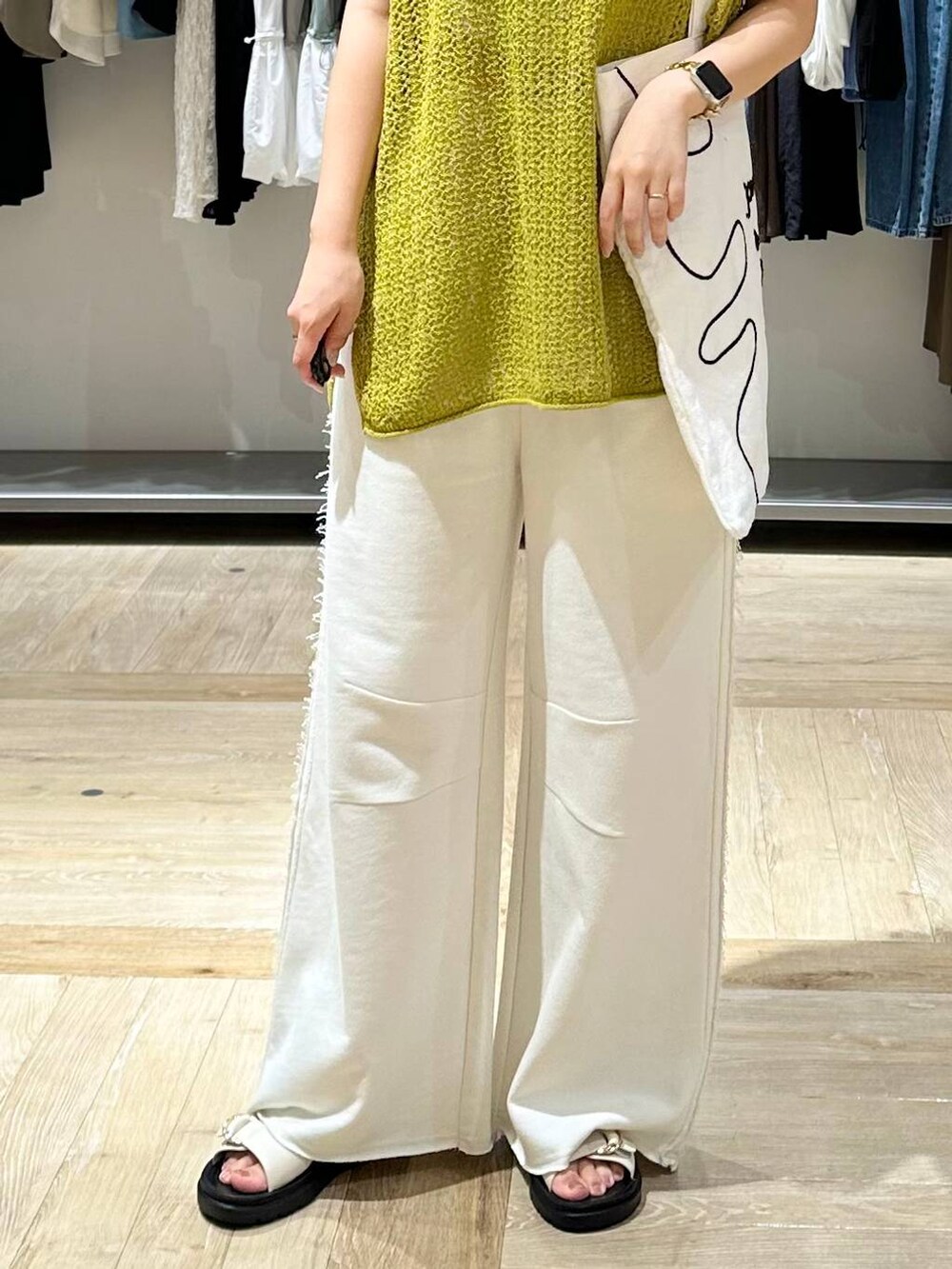 ホワイト系のスウェットパンツ、ホワイト系のサンダル、ホワイト系のトートバッグを着用したレディースの夏コーディネートの5枚目の写真