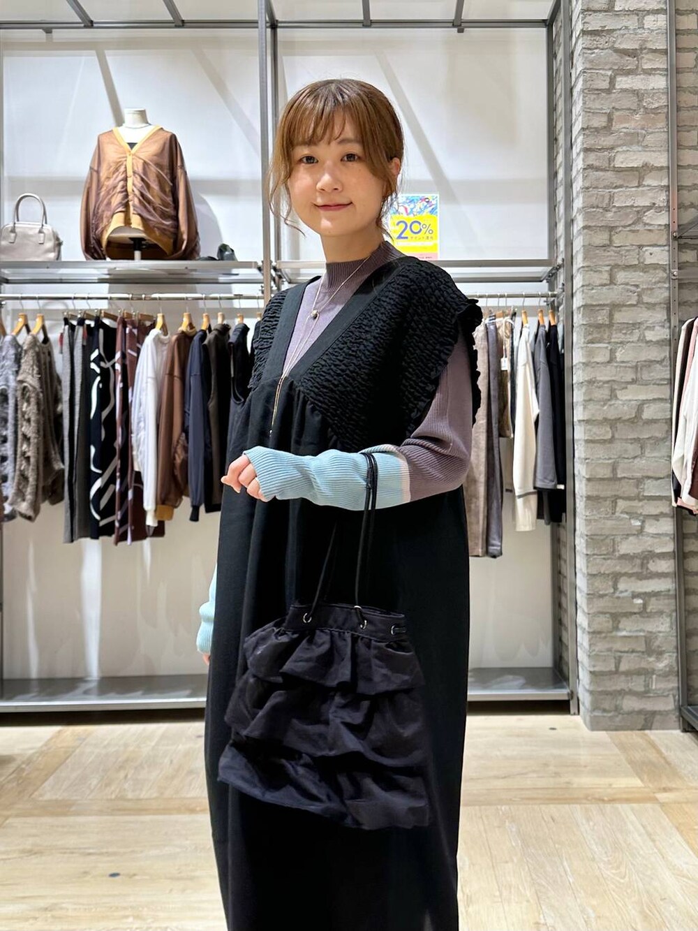 グレー系のニット/セーター、ブラック系のサンダル、ブラック系のショルダーバッグを着用したレディースの秋コーディネートの4枚目の写真