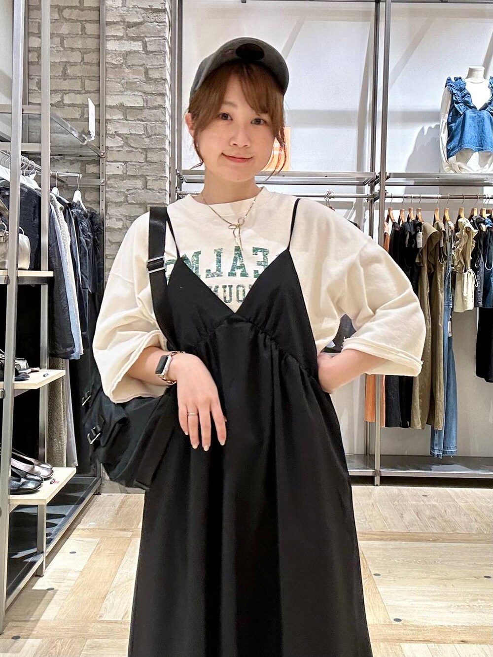 ブラック系のデニムパンツ、ブラック系のショルダーバッグ、ブラック系のサンダルを着用したレディースの春コーディネートの4枚目の写真