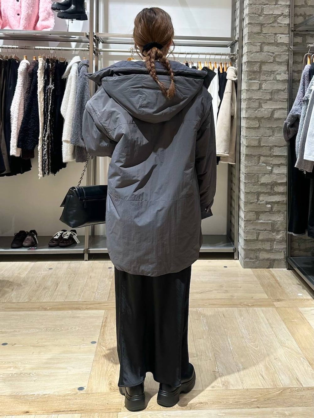 ブラック系のスカート、グレー系のその他アウター、ブラック系のブーツを着用したレディースの冬コーディネートの3枚目の写真