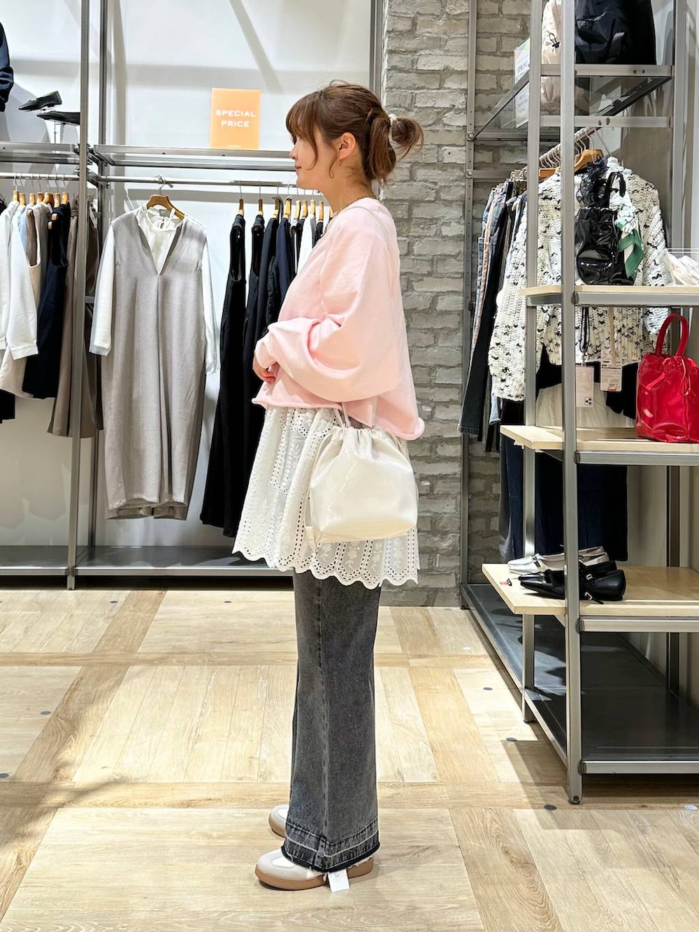 ホワイト系のTシャツ/カットソー、ブラック系のデニムパンツ、ホワイト系のスニーカーを着用したレディースの春コーディネートの3枚目の写真