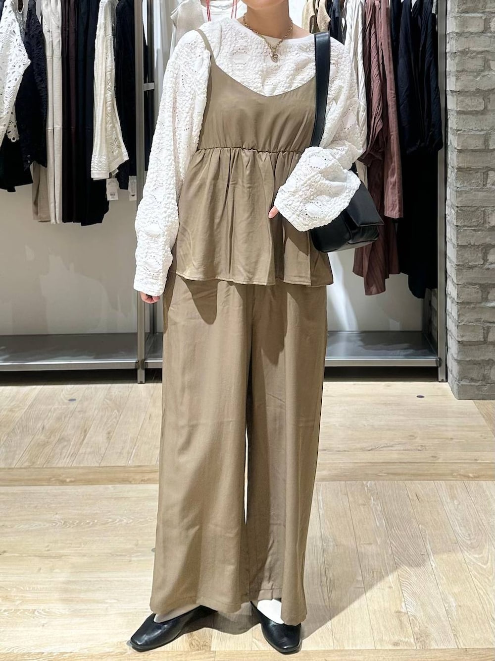 ブラック系のショルダーバッグ、ホワイト系のTシャツ/カットソー、ブラック系のパンプスを着用したレディースの春コーディネートの5枚目の写真