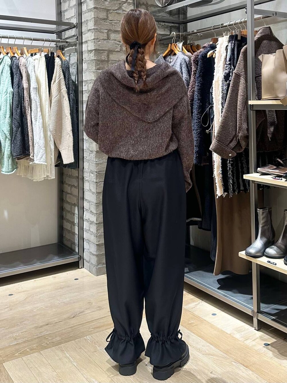 シルバー系のショルダーバッグ、ブラック系のその他パンツ、ブラック系のブーツを着用したレディースの秋コーディネートの3枚目の写真