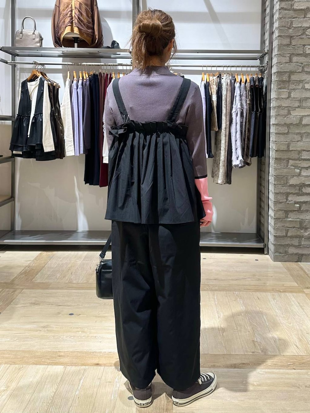 グレー系のニット/セーター、イエロー系のスニーカー、ブラック系のショルダーバッグを着用したレディースの秋コーディネートの4枚目の写真