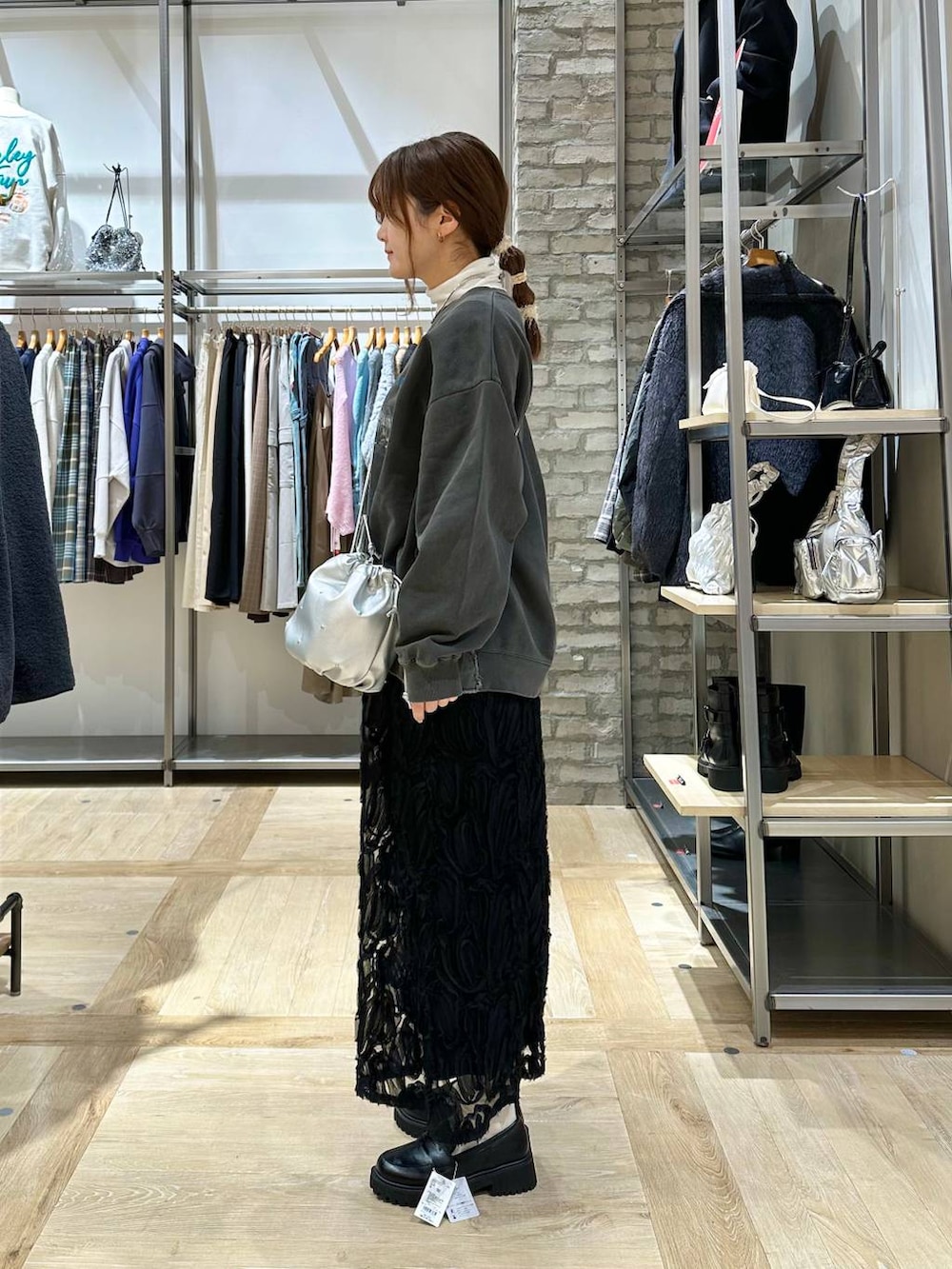 ブラック系のポンチョ、ブラック系のローファー、シルバー系のショルダーバッグを着用したレディースの冬コーディネートの5枚目の写真