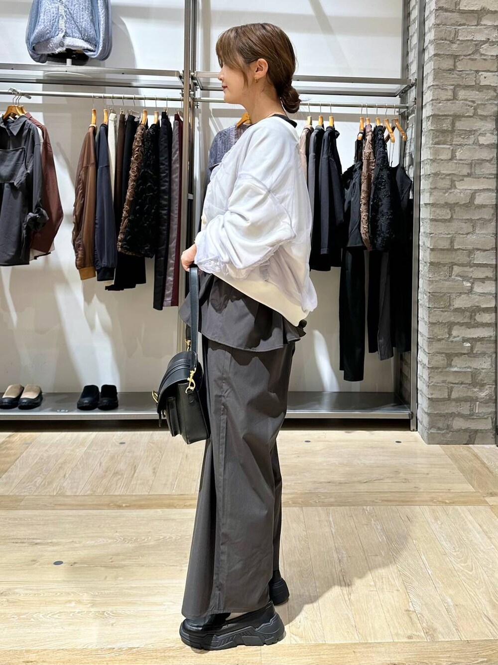 ブラック系のスニーカー、ブラック系のショルダーバッグ、グレー系のサロペット/オーバーオールを着用したレディースの秋コーディネートの2枚目の写真