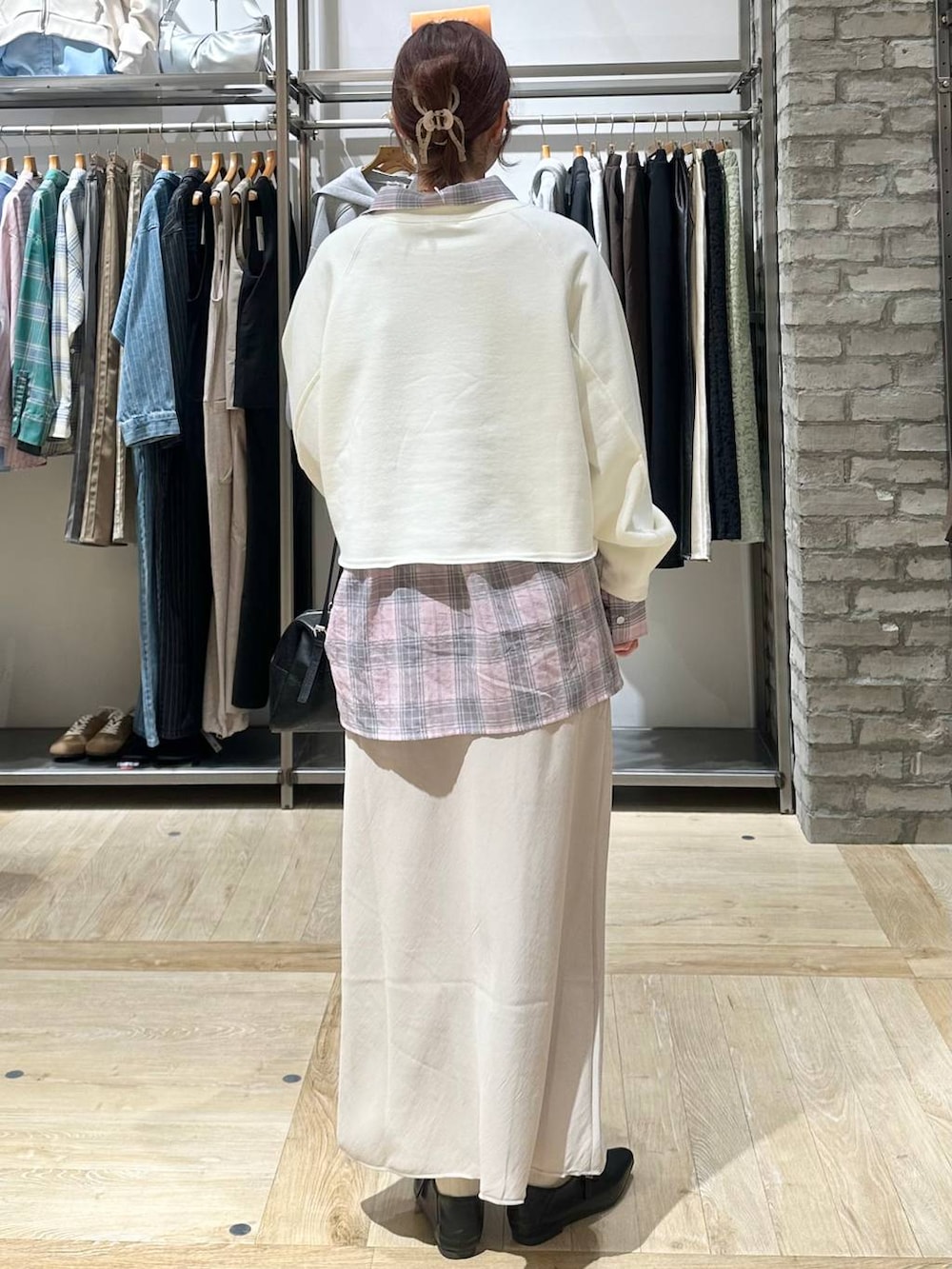 ブラック系のボストンバッグ、ベージュ系のスカート、ホワイト系のスウェットを着用したレディースの春コーディネートの3枚目の写真