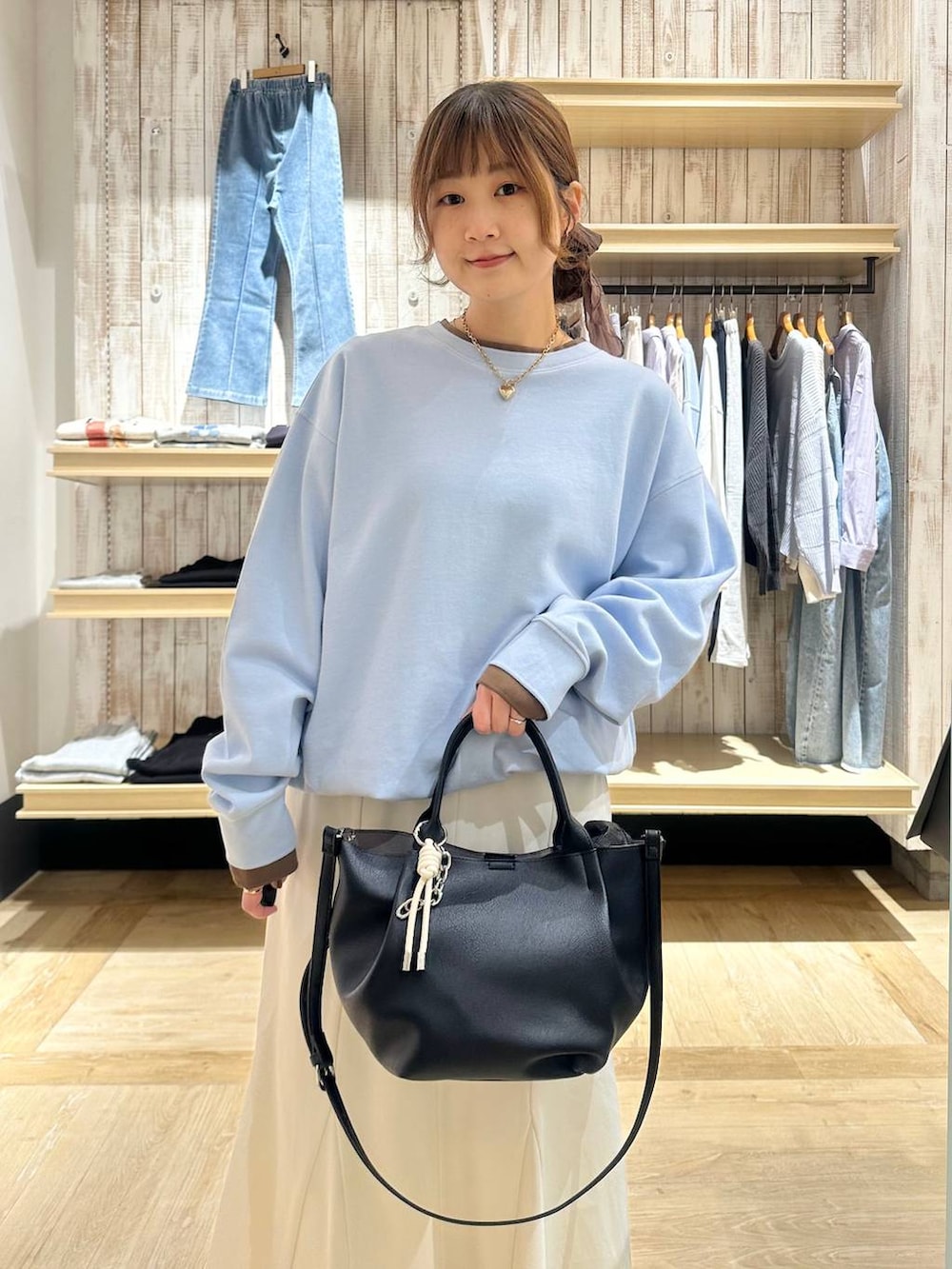 ホワイト系のスカート、ブラック系のトートバッグ、ブルー系のTシャツ/カットソーを着用したレディースの冬コーディネートの4枚目の写真