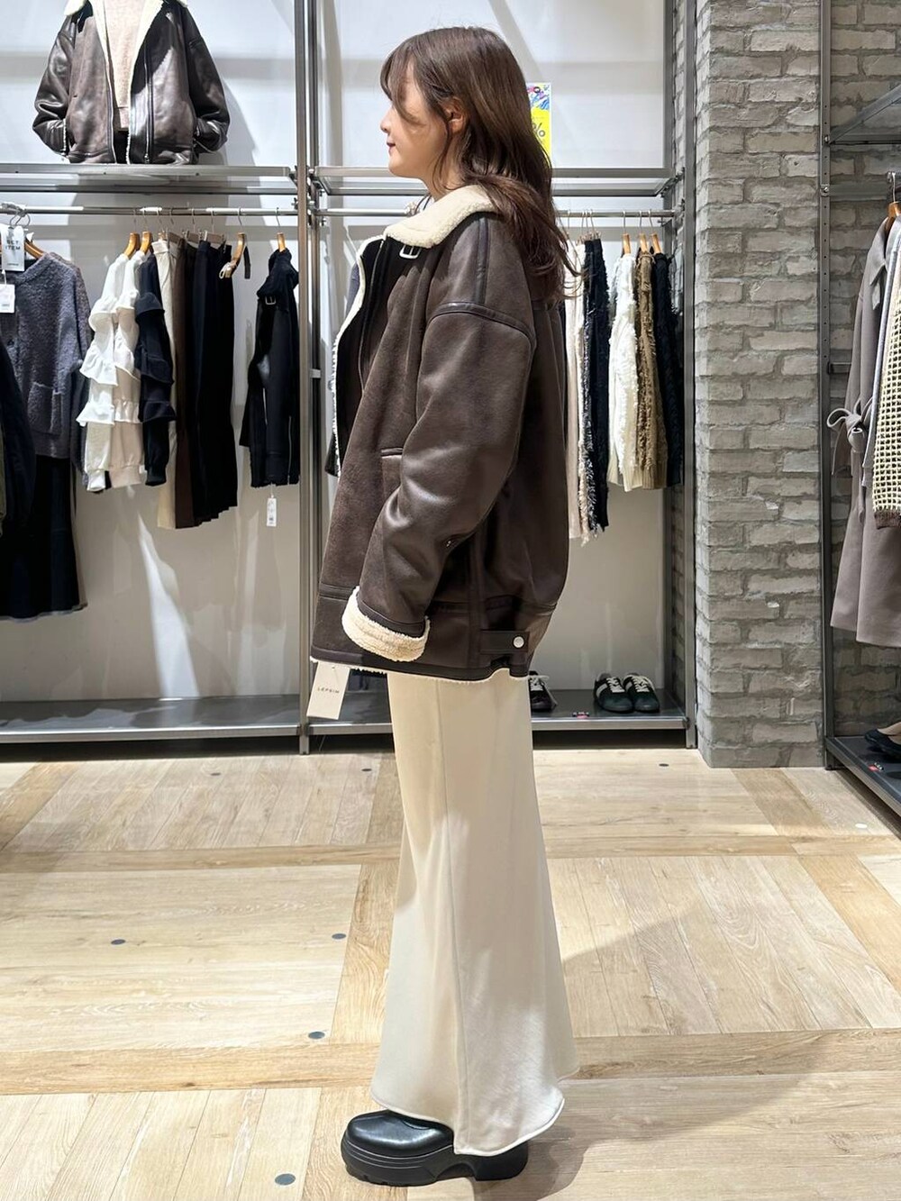 ホワイト系のスカート、ブラウン系のニット/セーター、ブラウン系のその他アウターを着用したレディースの秋コーディネートの2枚目の写真