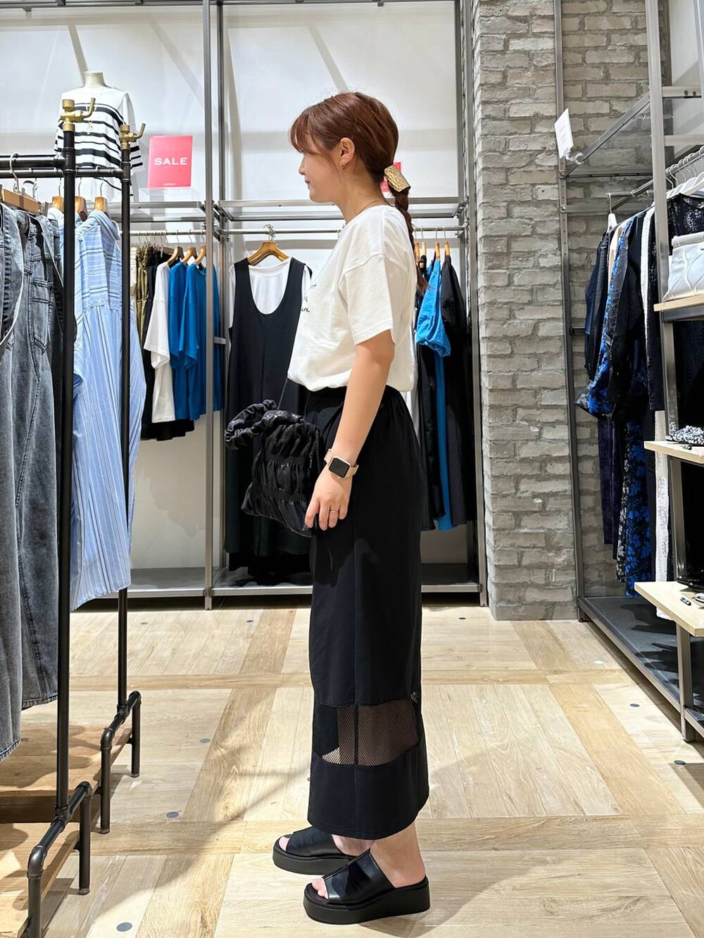 ホワイト系のTシャツ/カットソー、ブラック系のスカート、ブラック系のサンダルを着用したレディースの夏コーディネートの2枚目の写真