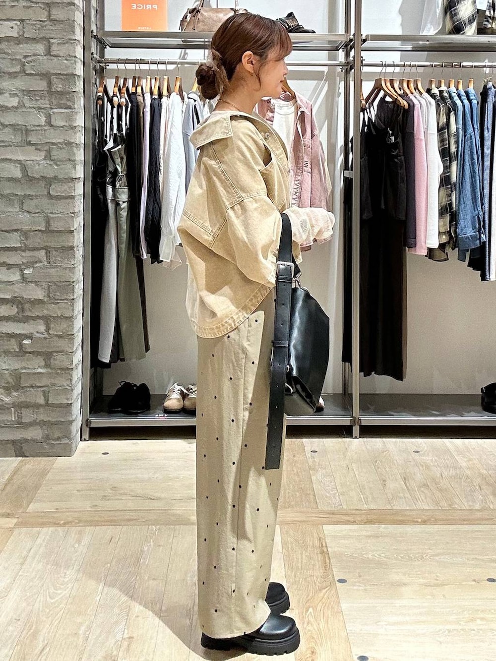 ブラック系のショルダーバッグ、ブラック系のその他シューズ、ホワイト系のTシャツ/カットソーを着用したレディースの春コーディネートの3枚目の写真