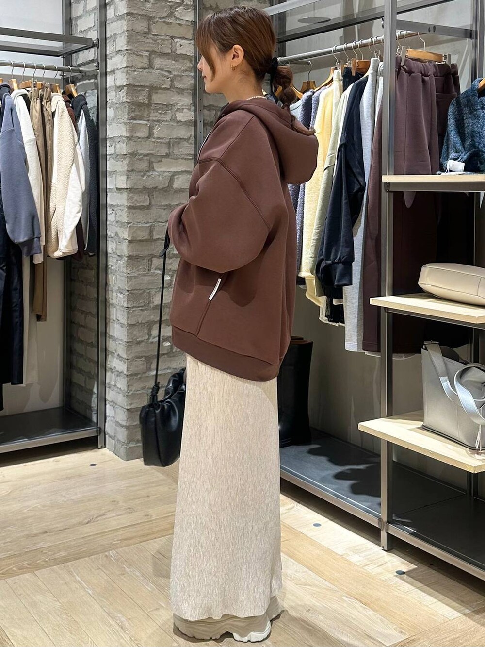 ホワイト系のブーツ、ブラウン系のニット/セーター、ホワイト系のその他アウターを着用したレディースの冬コーディネートの2枚目の写真