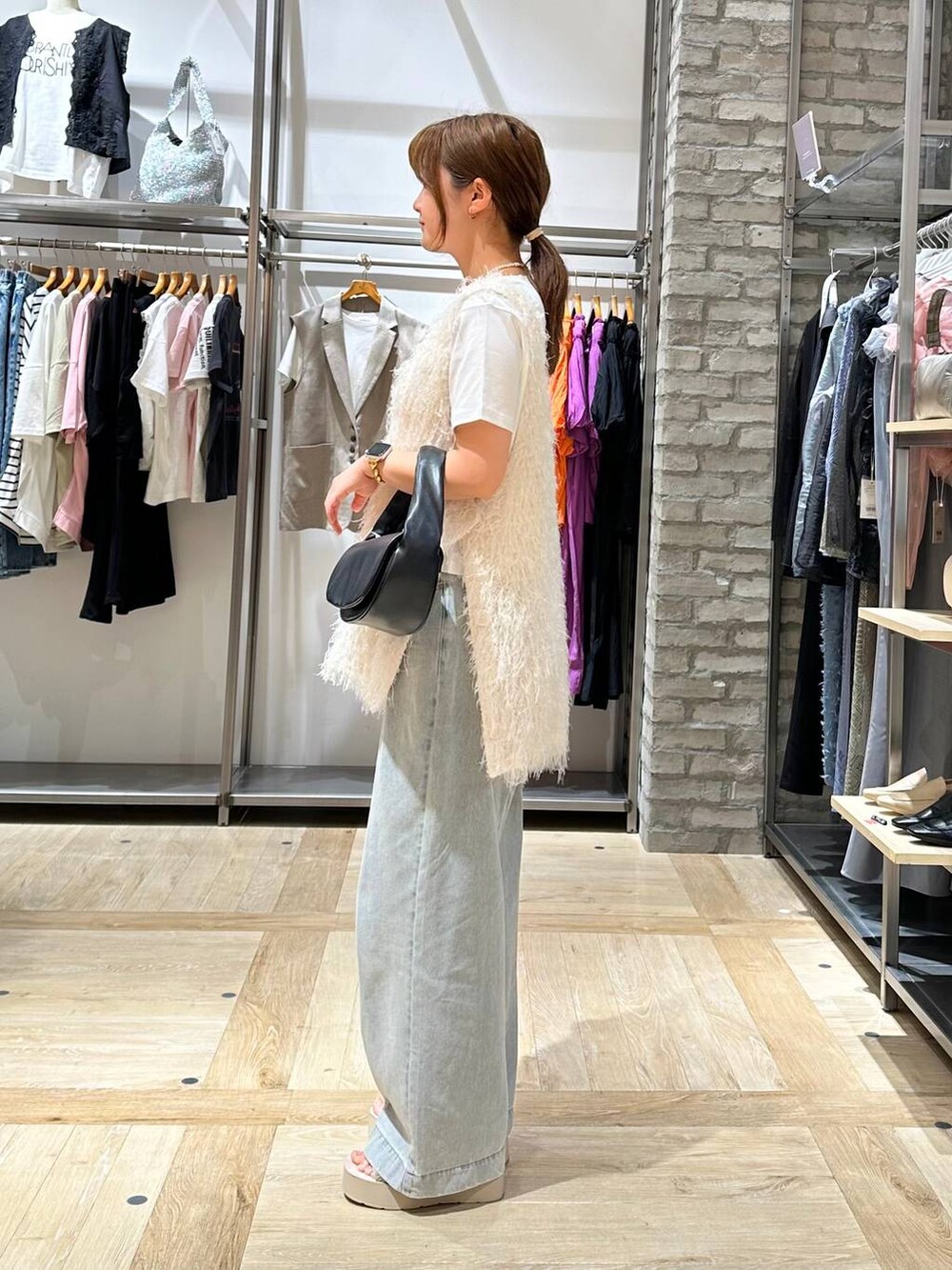 ホワイト系のTシャツ/カットソー、ホワイト系のサンダル、ブラック系のハンドバッグを着用したレディースの春コーディネートの3枚目の写真