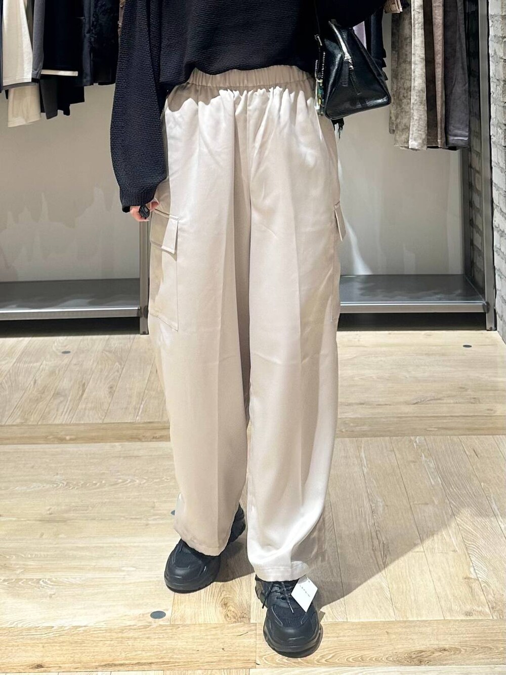 ブラック系のニット/セーター、ブラック系のスニーカー、ホワイト系のその他パンツを着用したレディースの秋コーディネートの6枚目の写真