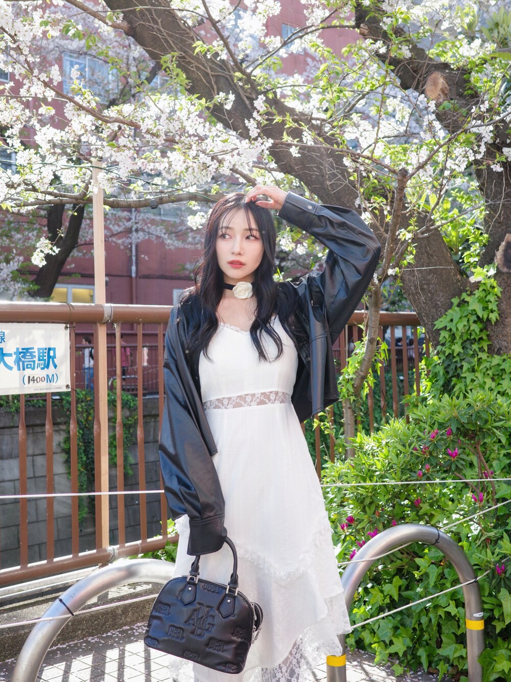 ホワイト系のワンピース、ブラック系のショルダーバッグ、ブラック系のトップスを着用したレディースの夏コーディネートの3枚目の写真