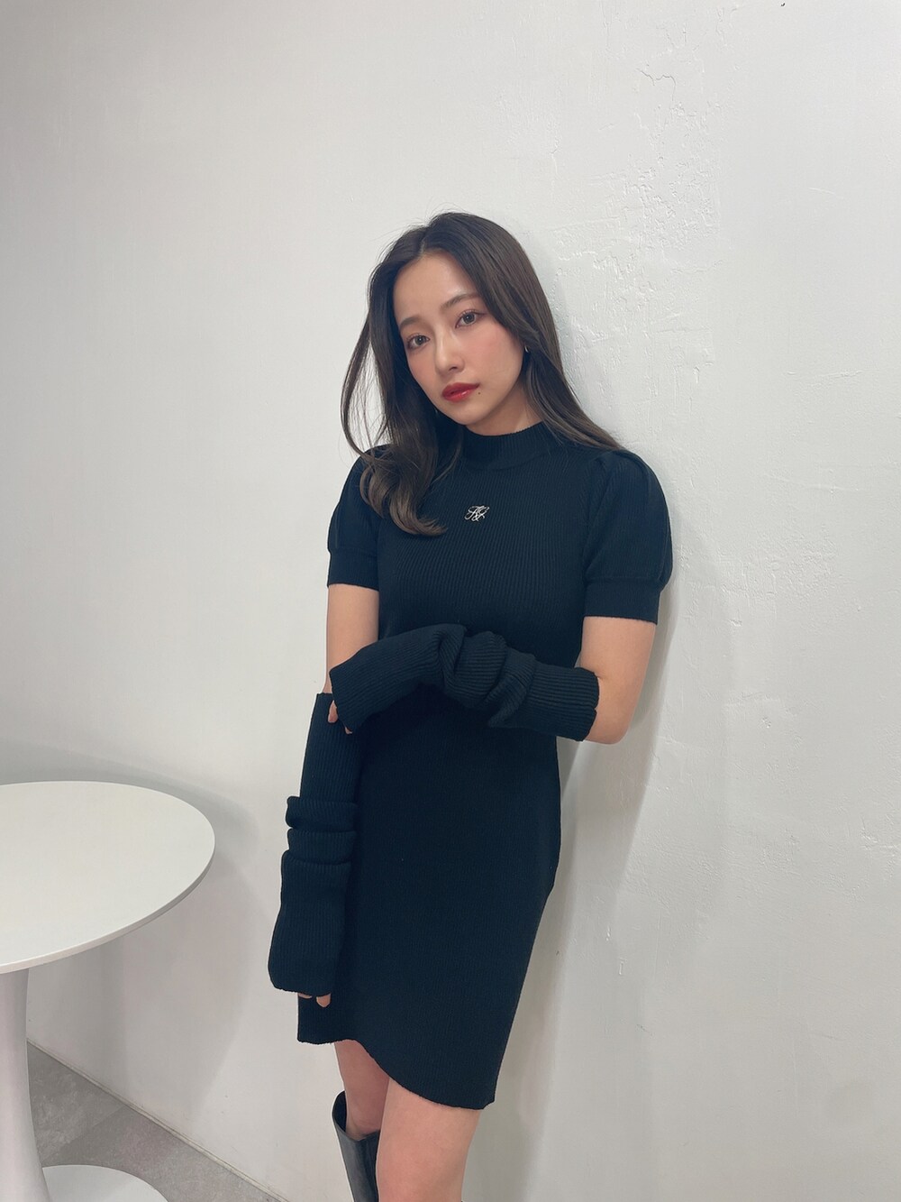 ブラック系のワンピース、ベージュ系のショルダーバッグを着用したレディースの春コーディネートの3枚目の写真