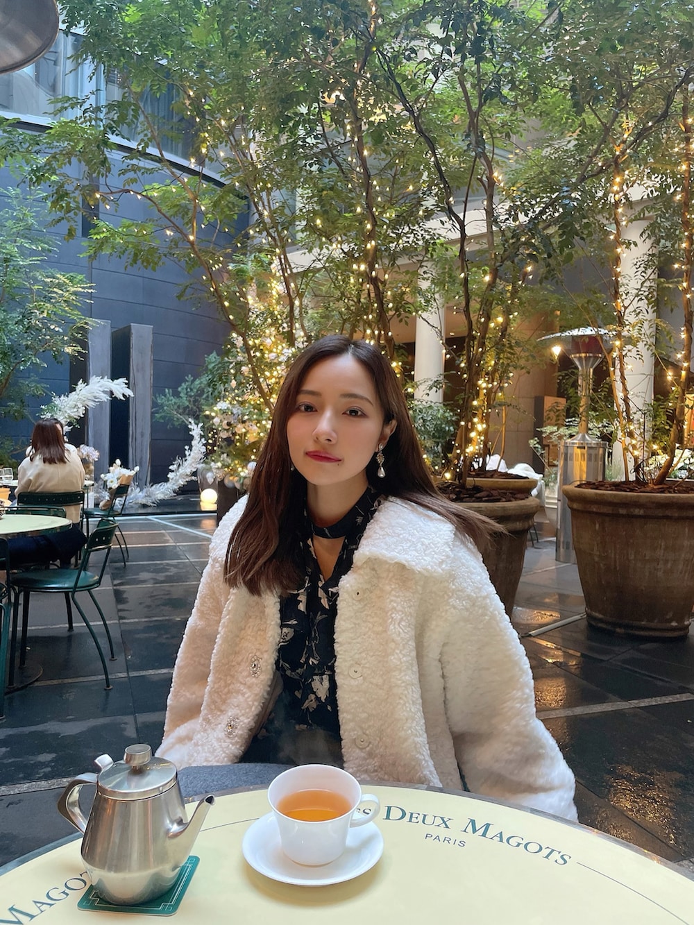 ブラック系のワンピース、ホワイト系のダウンジャケット/コートを着用したレディースの春コーディネートの5枚目の写真